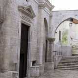 L'altra entrata si apre sul prospetto ovest dell'edificio, vicino a un elegante arco e a una scalinata che un tempo immettevano in un particolare ospedale. Il luogo di ricovero accoglieva infatti guerrieri e religiosi tornati dalla Palestina ammalati o feriti